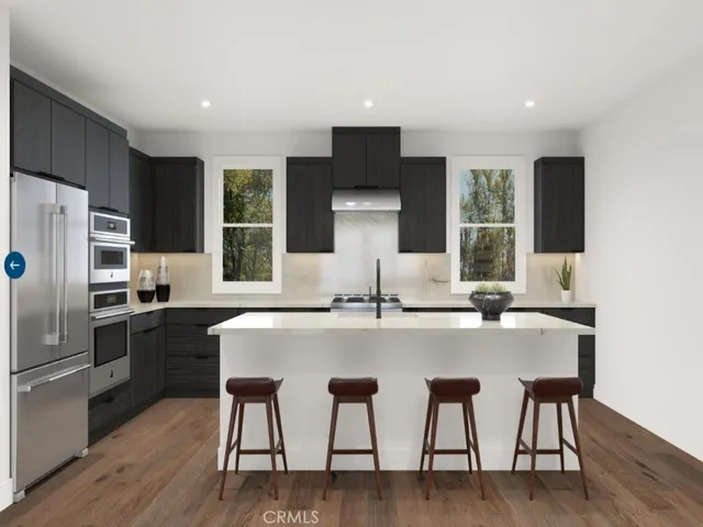 a kitchen with a table chairs refrigerator and microwave