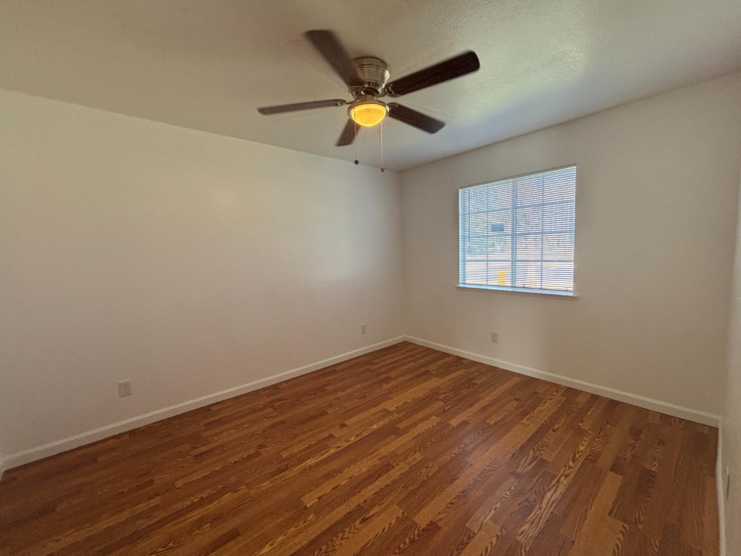 813 Morton Avenue Sanger, CA 93657 - Photo 14 of 19 an empty room with wooden floor and windows