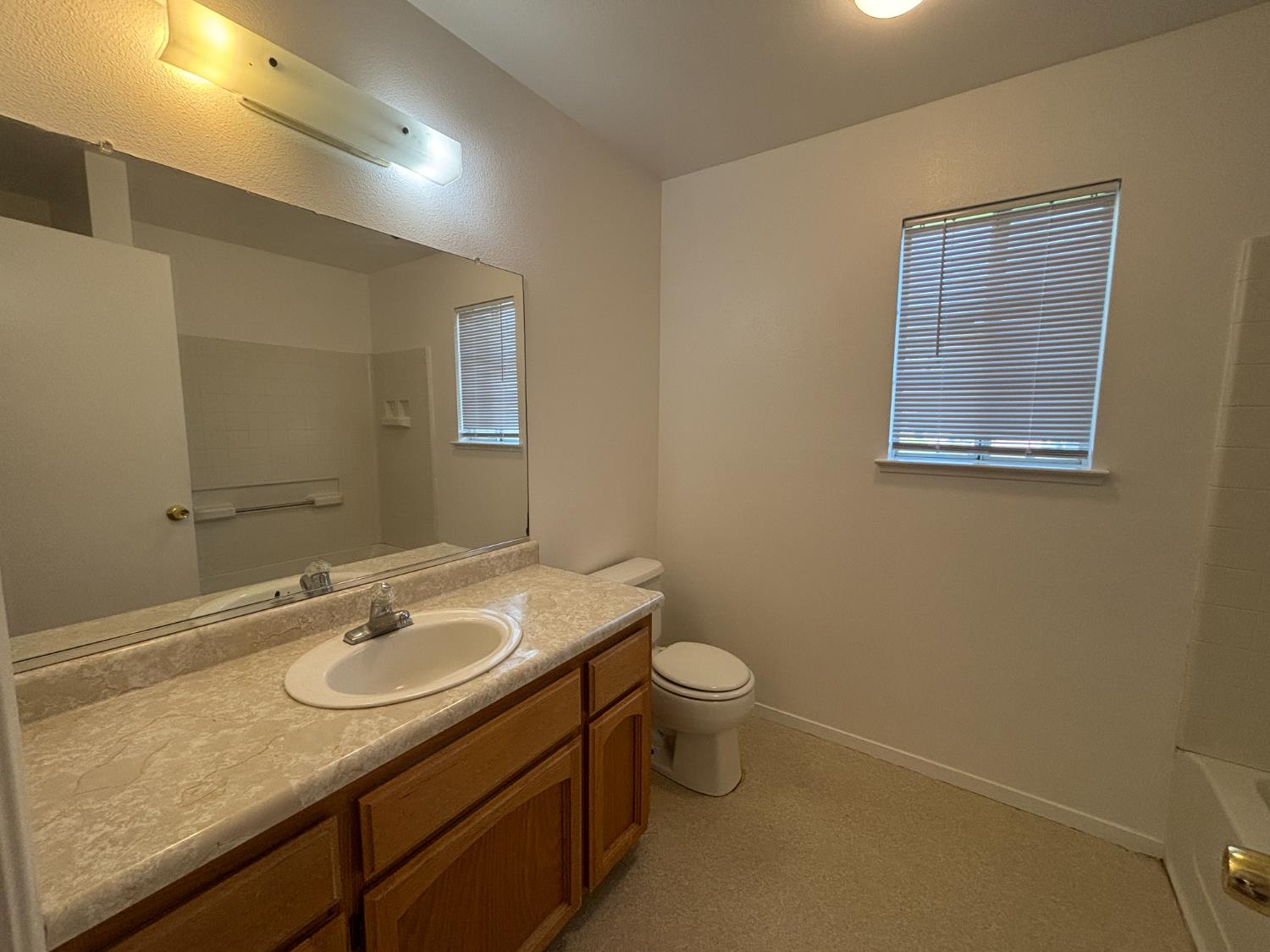 813 Morton Avenue Sanger, CA 93657 - Photo 16 of 19 a bathroom with a granite countertop sink toilet and mirror