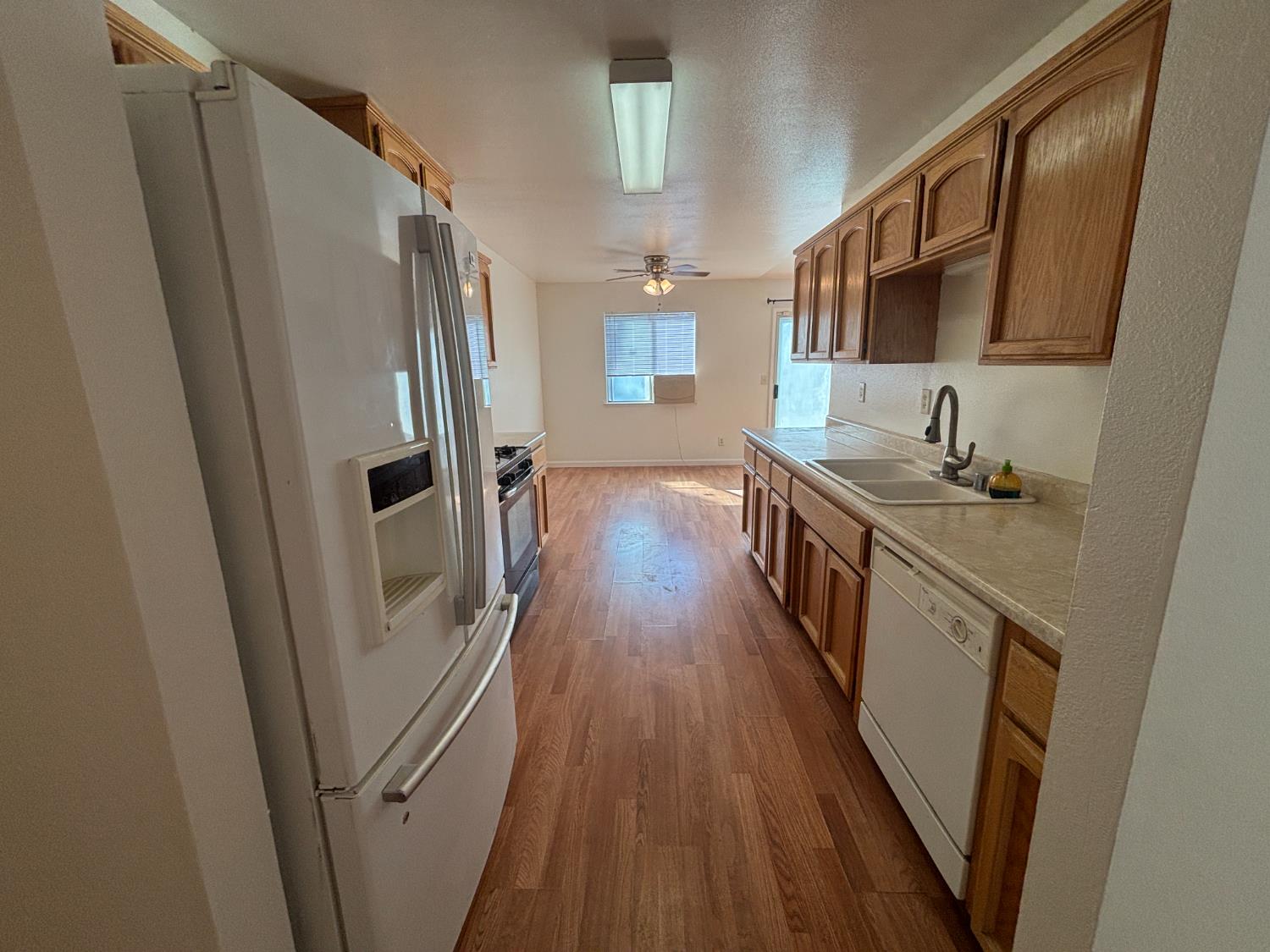 813 Morton Avenue Sanger, CA 93657 - Photo 7 of 19 a kitchen with sink a refrigerator a stove and wooden floor