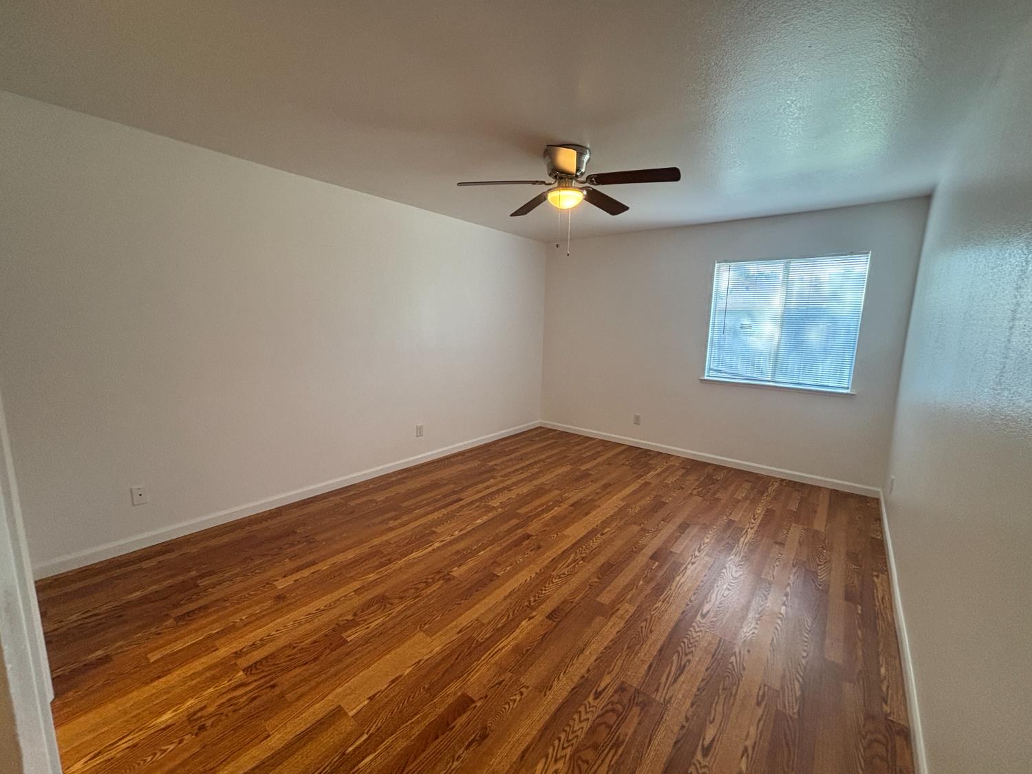 813 Morton Avenue Sanger, CA 93657 - Photo 8 of 19 wooden floor in an empty room with a window