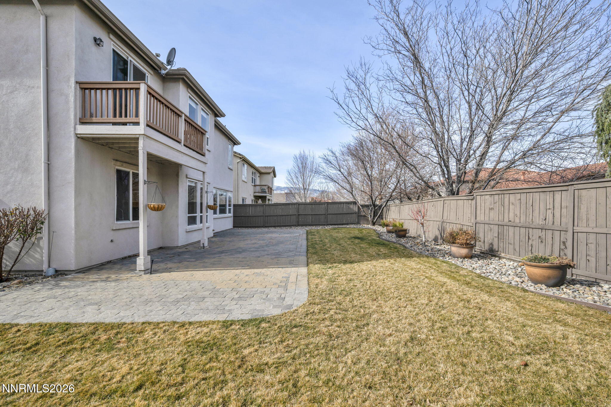 475 Parade Drive Reno, NV 89521 - Photo 39 of 113 a view of a white house with a large tree and wooden fence