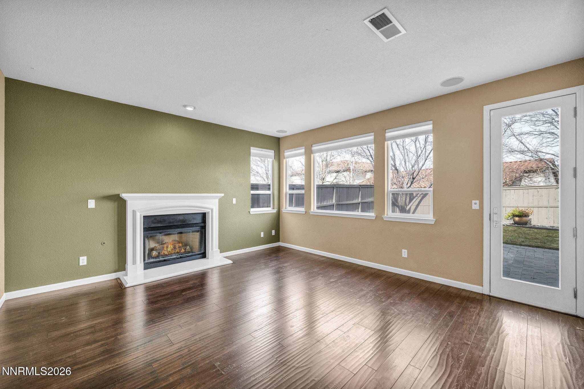 475 Parade Drive Reno, NV 89521 - Photo 70 of 113 an empty room with wooden floor fireplace and windows