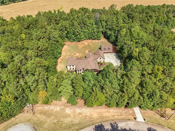 a front view of house with yard and trees in the background