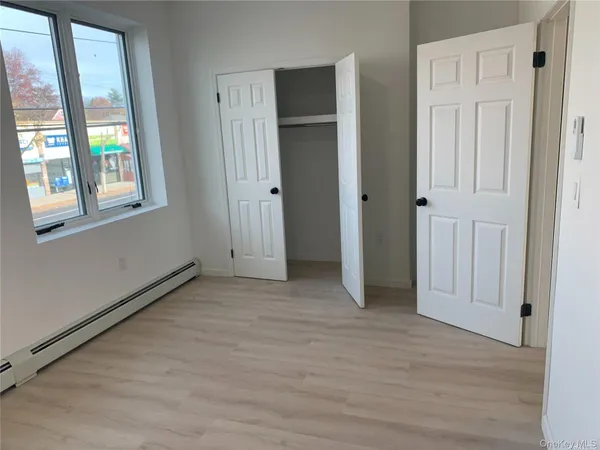 an empty room with windows and closet