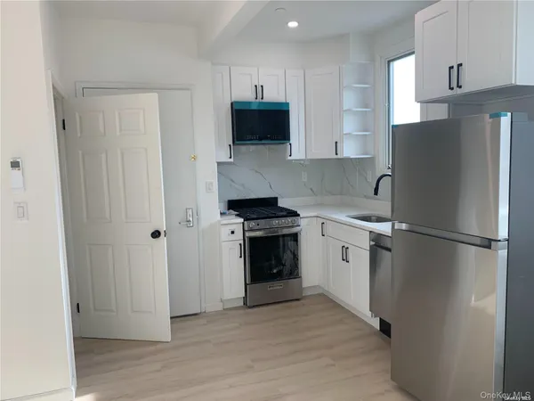 a kitchen with a refrigerator stove and white cabinets