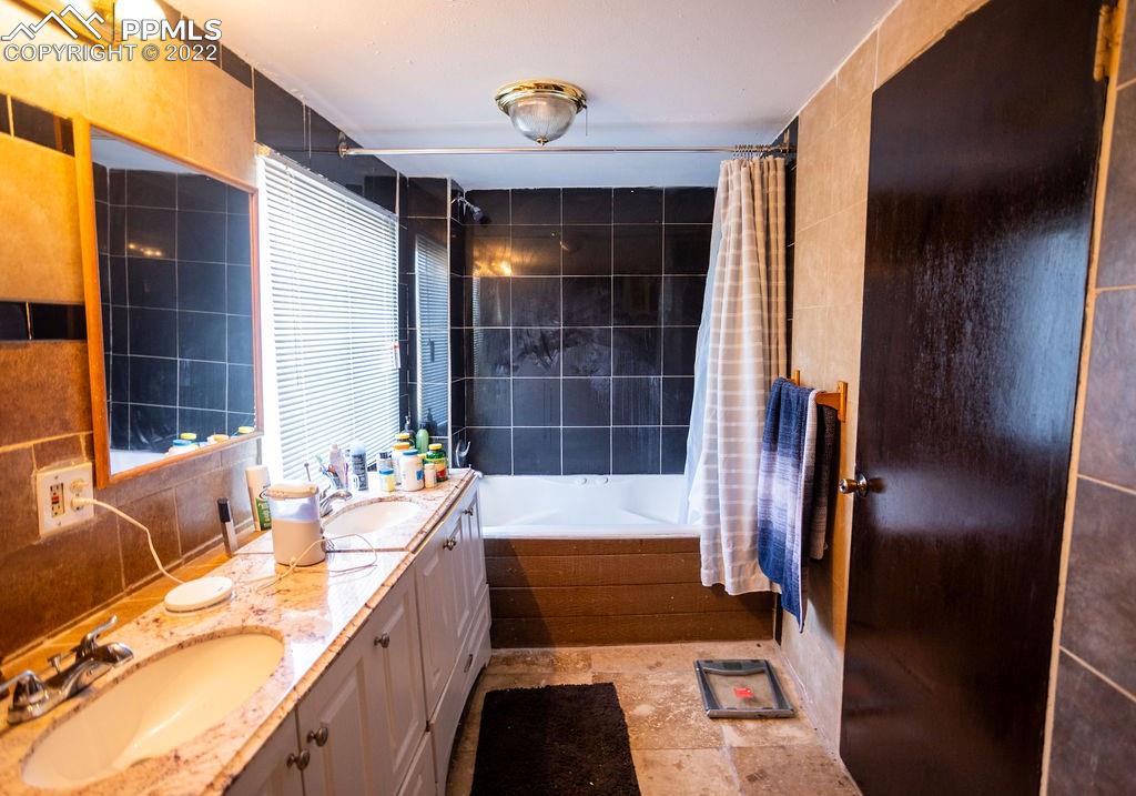 30915 Washington Road Calhan, CO 80808 - Photo 14 of 29 a bathroom with a tub sink and double vanity