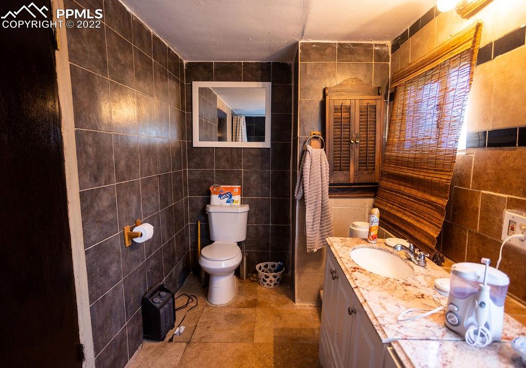 30915 Washington Road Calhan, CO 80808 - Photo 15 of 29 a bathroom with a sink mirror vanity and toilet