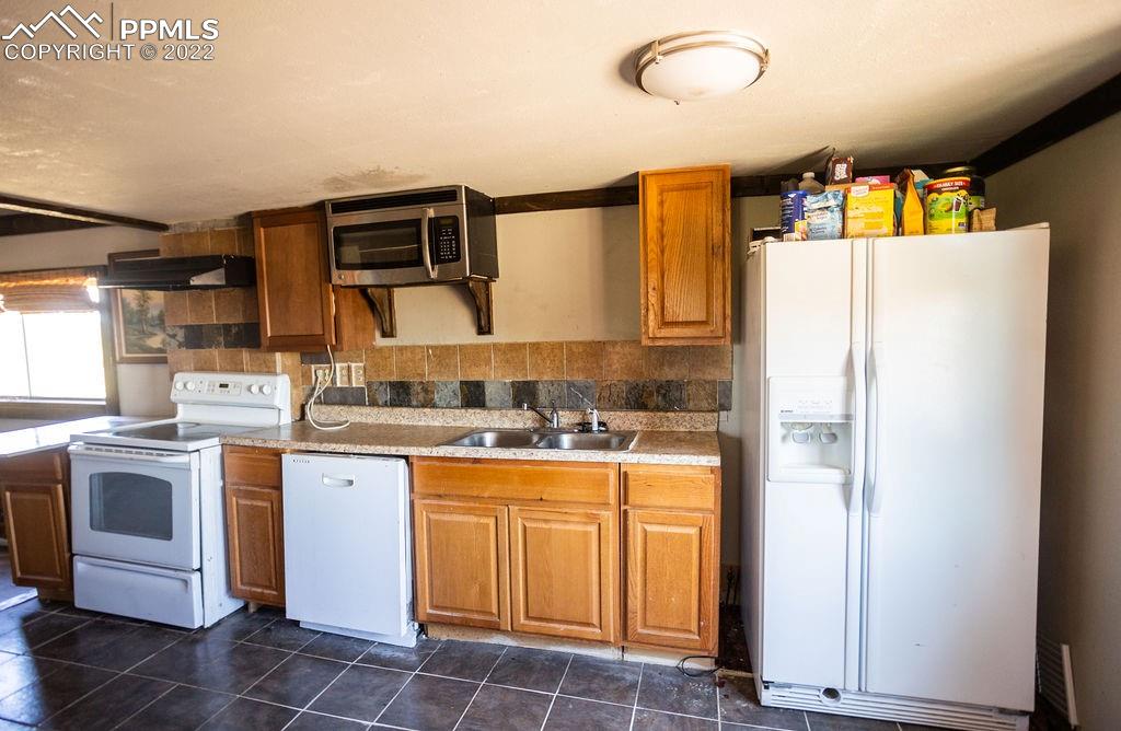 30915 Washington Road Calhan, CO 80808 - Photo 3 of 29 a kitchen with a sink a stove and refrigerator