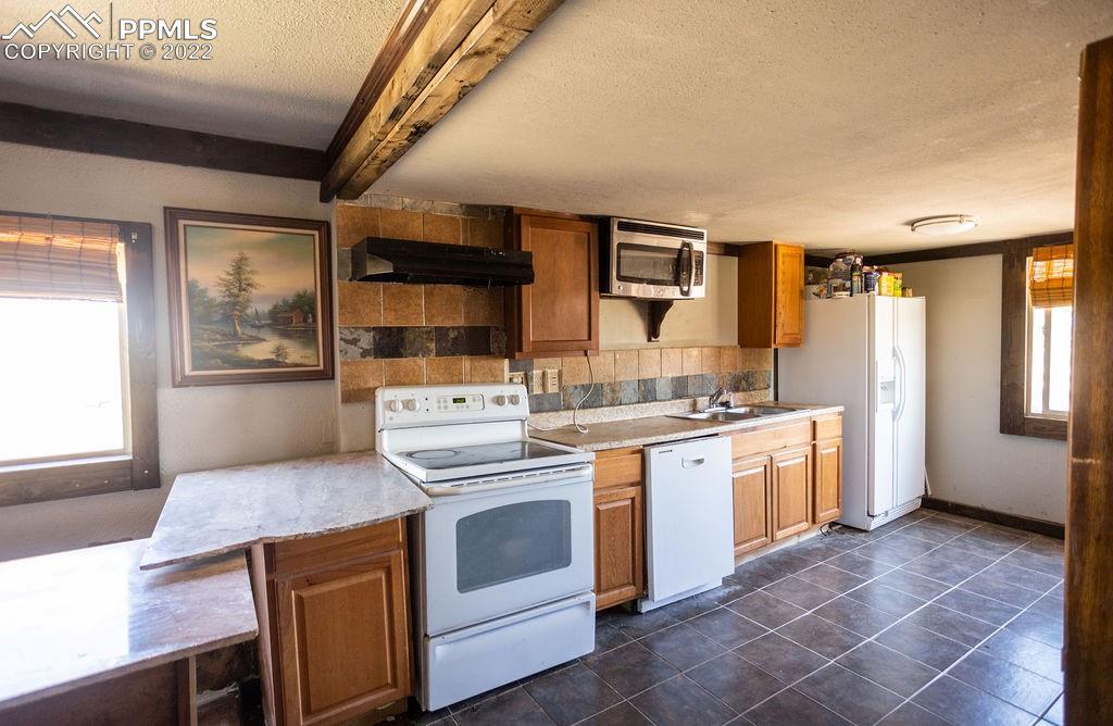 30915 Washington Road Calhan, CO 80808 - Photo 4 of 29 a kitchen with stainless steel appliances granite countertop a stove and a sink