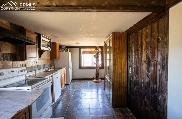 a kitchen with stainless steel appliances granite countertop a refrigerator a sink dishwasher and wooden cabinets