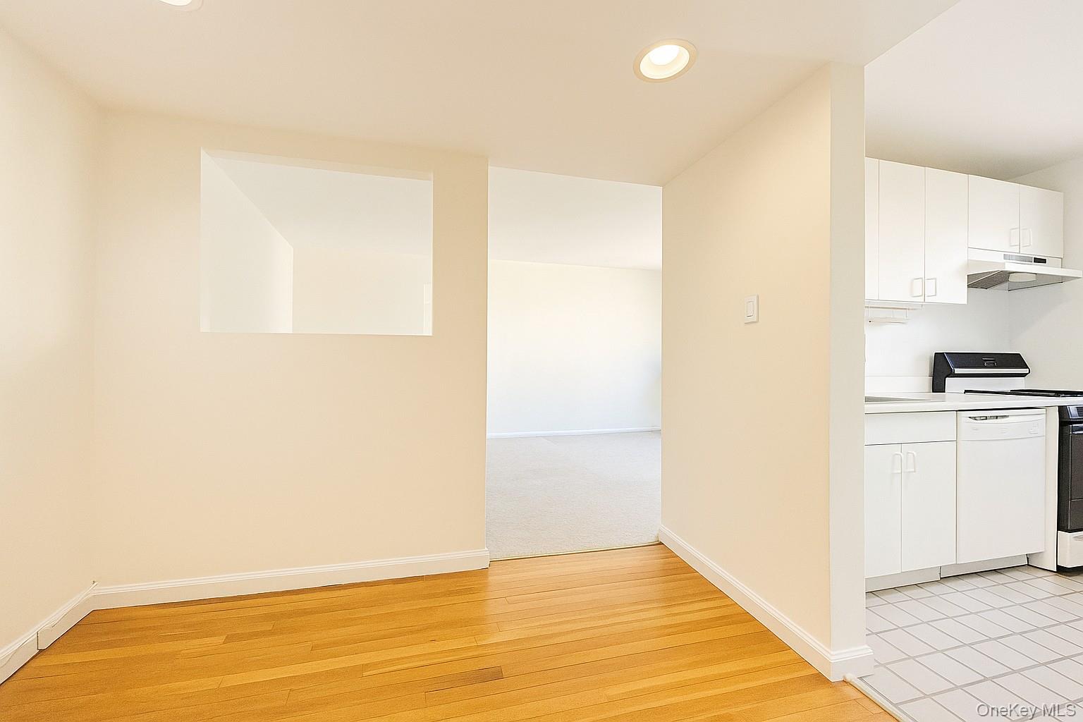 7 Terrace, Unit 3H Great Neck, NY 11021 - Photo 5 of 37 a view of kitchen and empty room with wooden floor