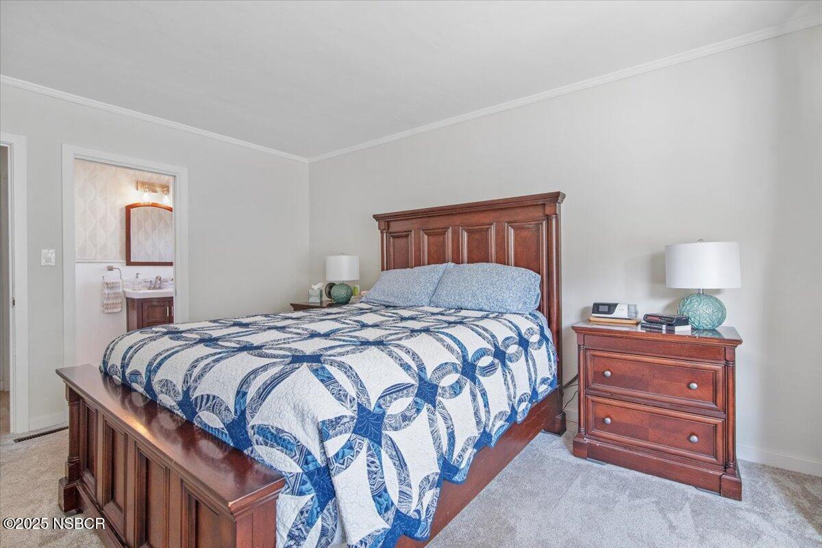 335 South F Street Lompoc, CA 93436 - Photo 21 of 44 a bedroom with a bed and a lamp on dresser