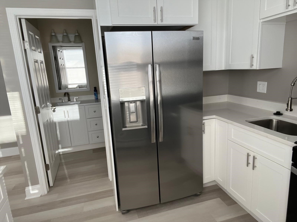 238 Appleton Street, Unit 1 Lowell, MA 01852 - Photo 2 of 5 a kitchen with metallic refrigerator freezer and a sink