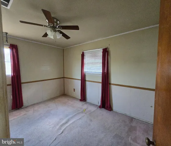 an empty room with window and a ceiling fan