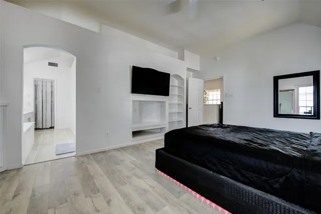 a bedroom with a bed and a flat screen tv