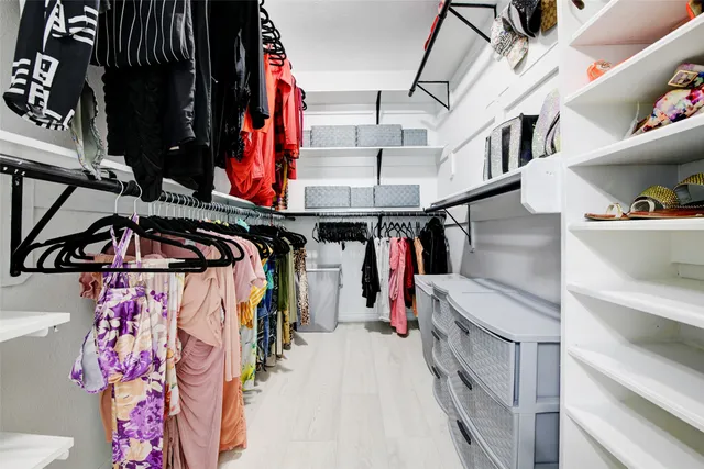 a view of walk in closet with clothes and shoes