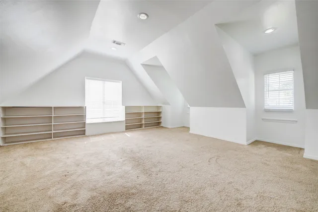 an empty room with stairs and windows