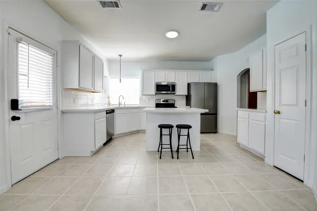 a kitchen with a sink a window and stainless steel appliances