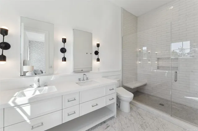 a bathroom with a double vanity sink toilet and shower