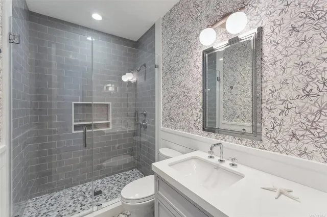 a bathroom with a sink a toilet and shower