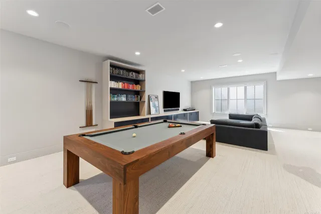 a living room with game table and a flat screen tv
