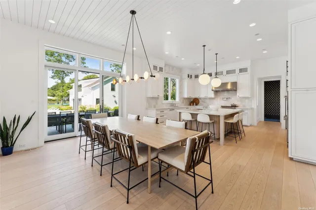 a view of a dining room and livingroom with furniture wooden floor a chandelier
