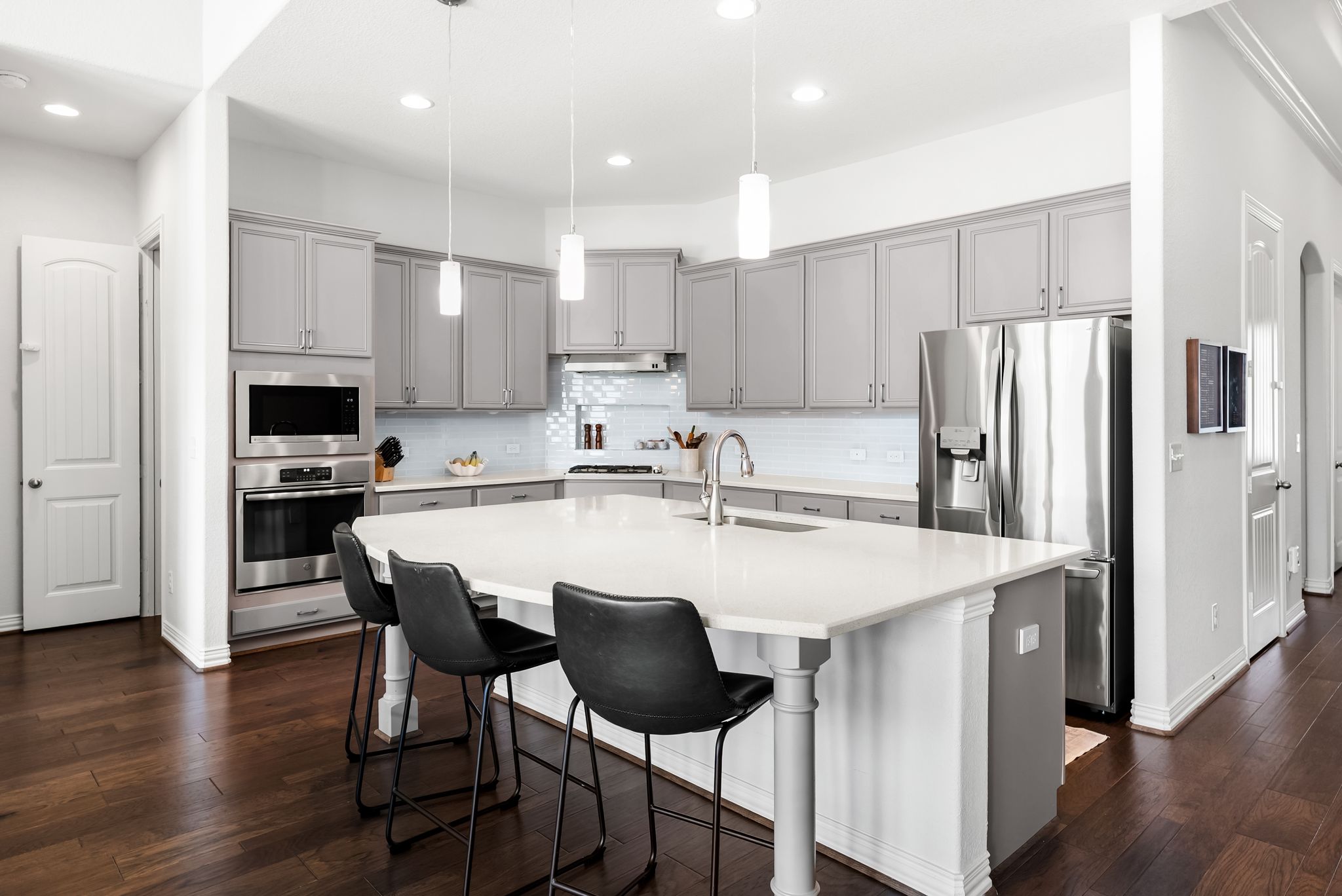19901 Isle Of Glass Street Pflugerville, TX 78660 - Photo 20 of 40 a kitchen with stainless steel appliances granite countertop a dining table chairs refrigerator and sink