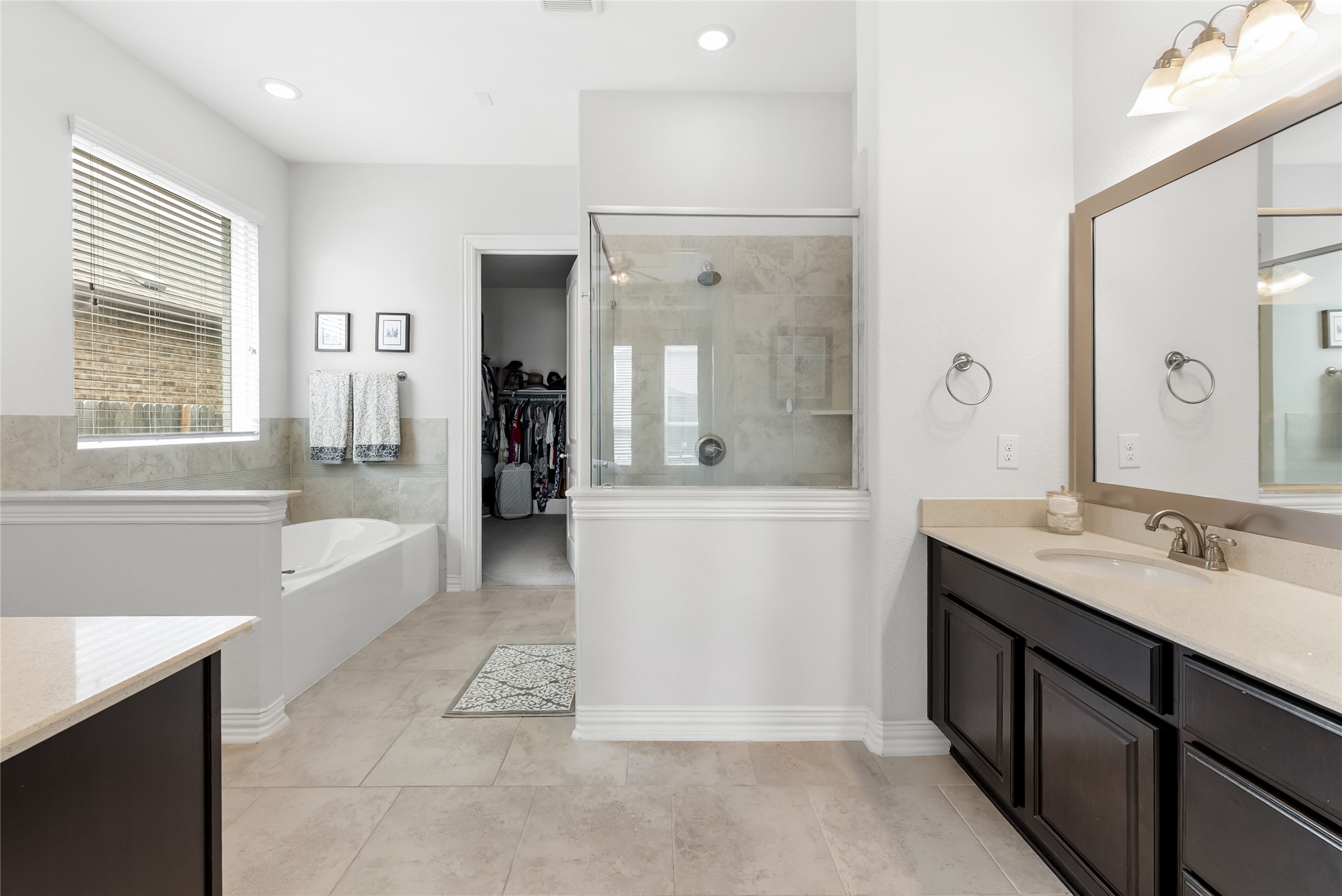 19901 Isle Of Glass Street Pflugerville, TX 78660 - Photo 28 of 40 a bathroom with a double vanity sink a bathtub and shower