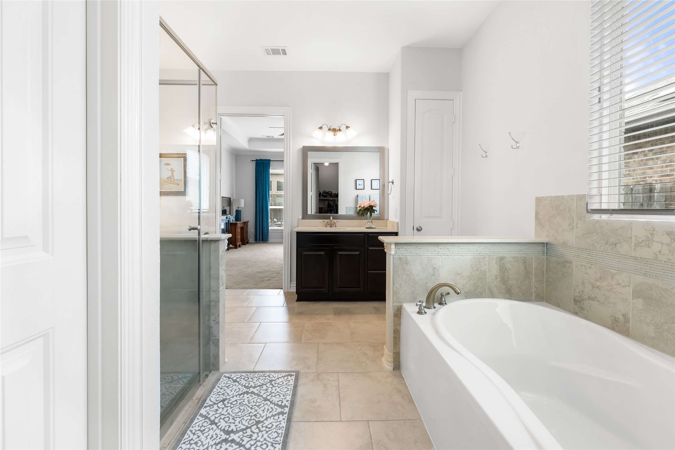 19901 Isle Of Glass Street Pflugerville, TX 78660 - Photo 29 of 40 a bathroom with a tub a sink and a mirror