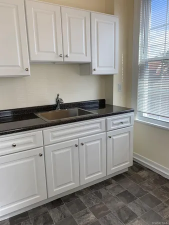a kitchen with granite countertop white cabinets and white appliances
