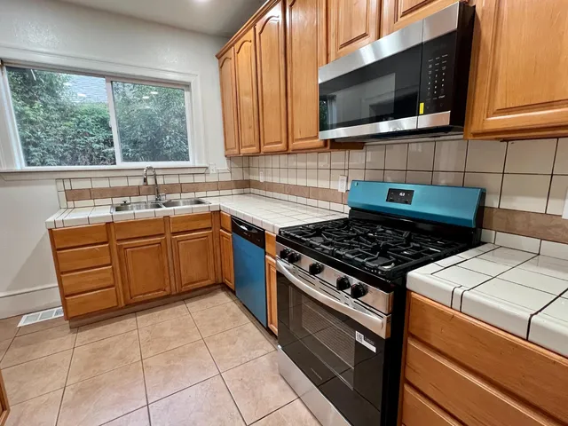 a kitchen with a stove a sink and a microwave