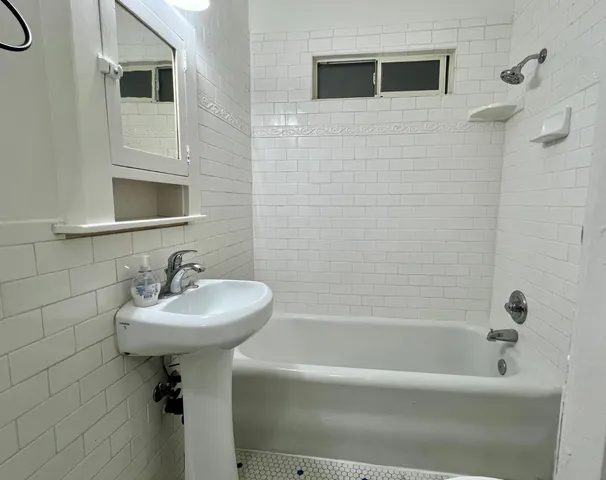 a bathroom with a sink a mirror bathtub and toilet