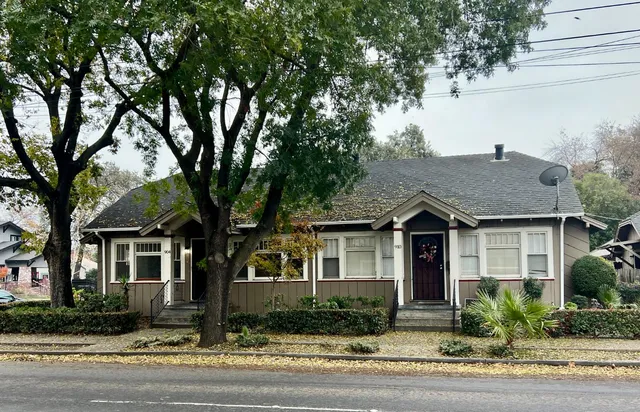 a front view of a house with yard and trees