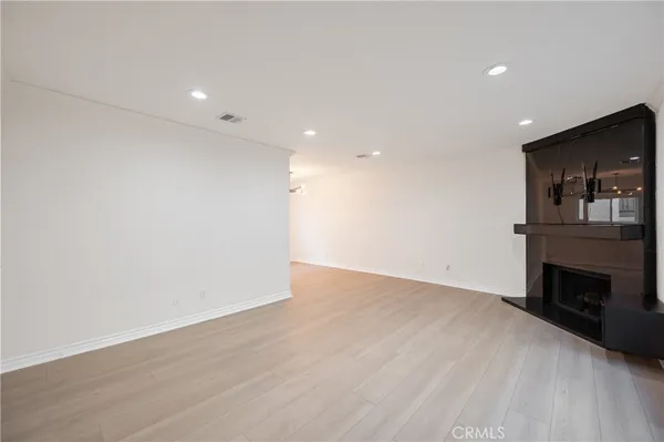 an empty room with wooden floor and fireplace
