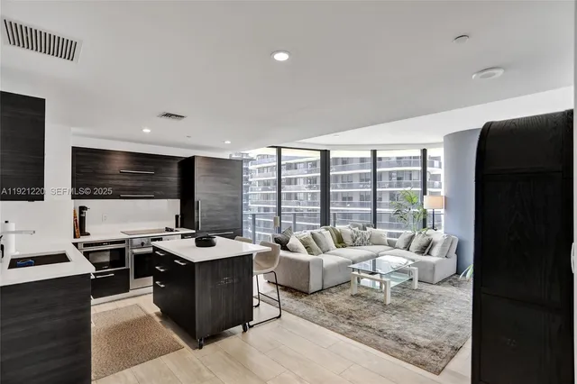 a living room with furniture flat screen tv and a floor to ceiling window