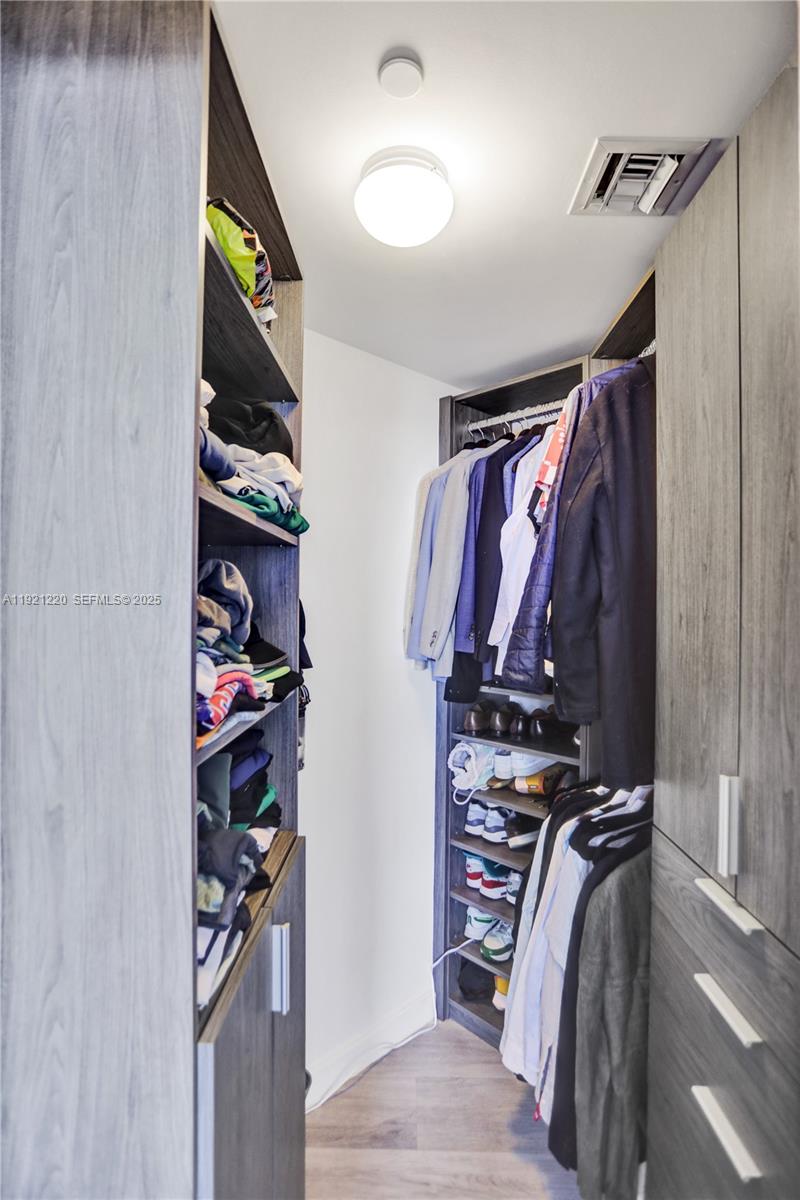 45 Southwest 9th Street, Unit 2001 Miami, FL 33130 - Photo 19 of 48 a view of walk in closet with clothes and shoes