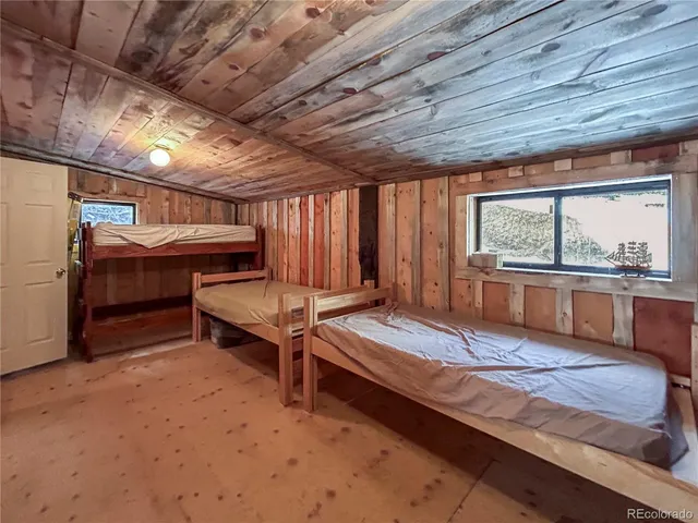 a bedroom with a bed and large windows