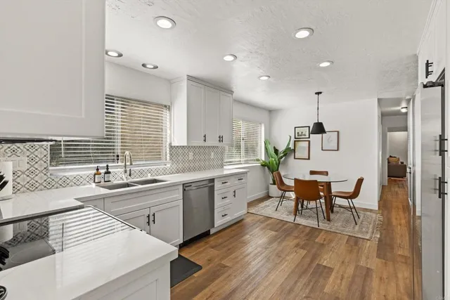 a bedroom with a bed a chair and potted plant on the dresser