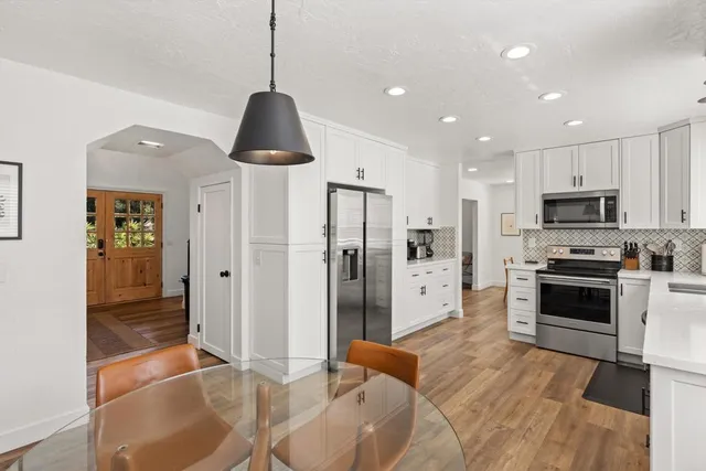 a living room with furniture a table and wooden floor