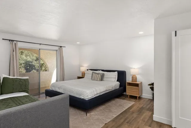 a bedroom with a bed and wooden floor