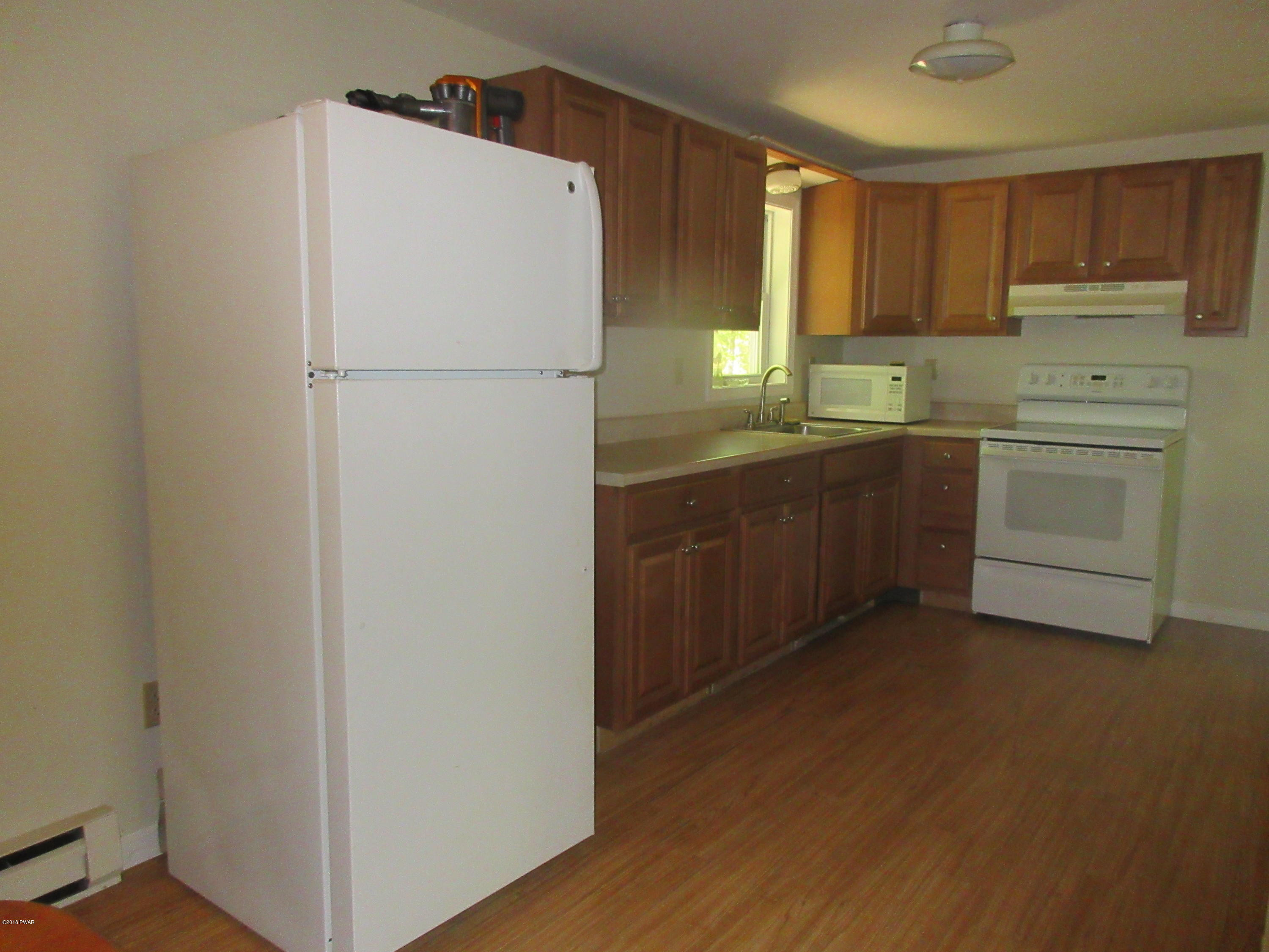 119 Skyview Road Dingmans Ferry, PA 18328 - Photo 5 of 12 a kitchen with a refrigerator sink and cabinets