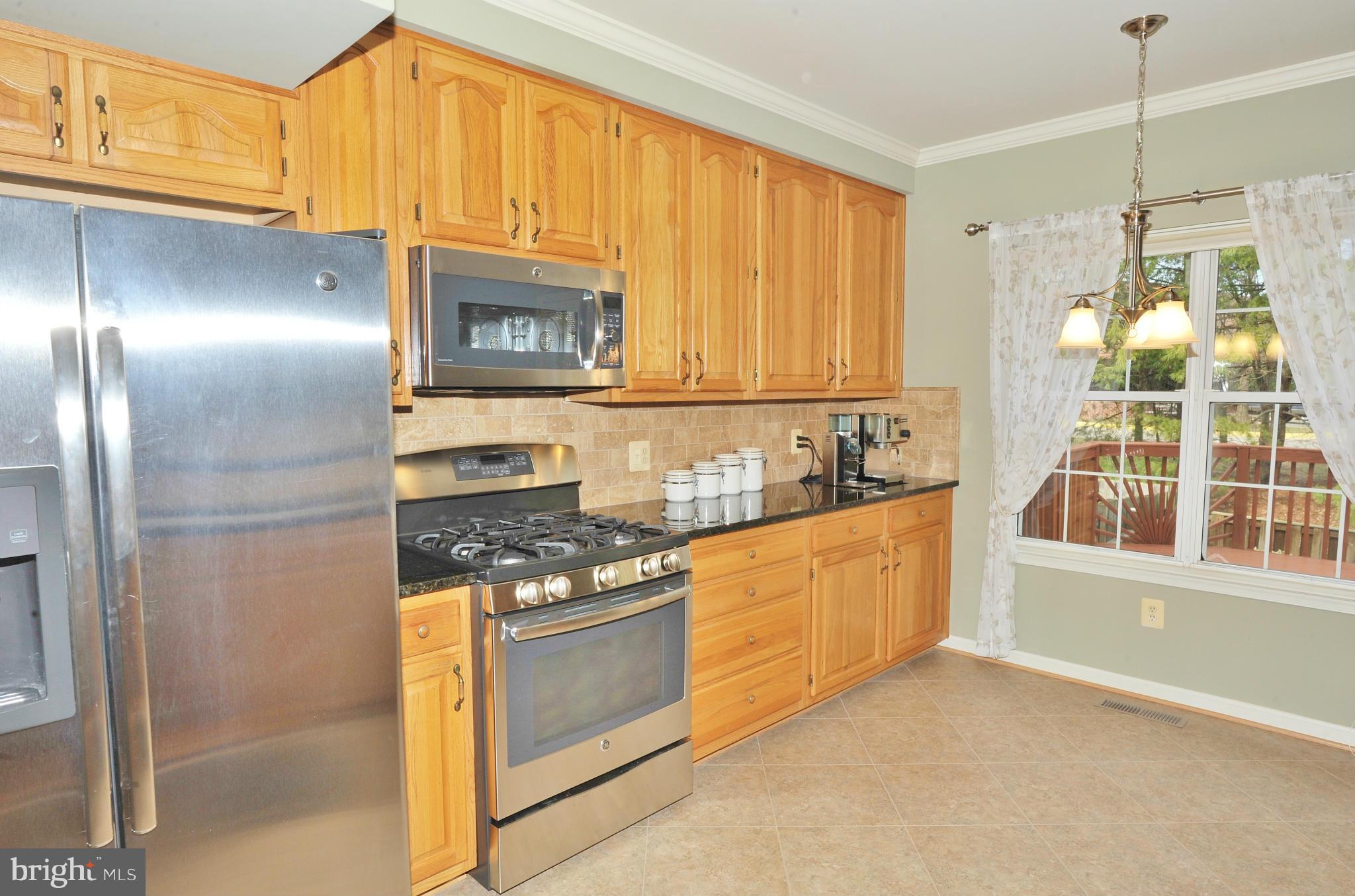 5700 Clapham Road Alexandria, VA 22315 - Photo 2 of 30 a kitchen with stainless steel appliances granite countertop a stove a sink and a refrigerator