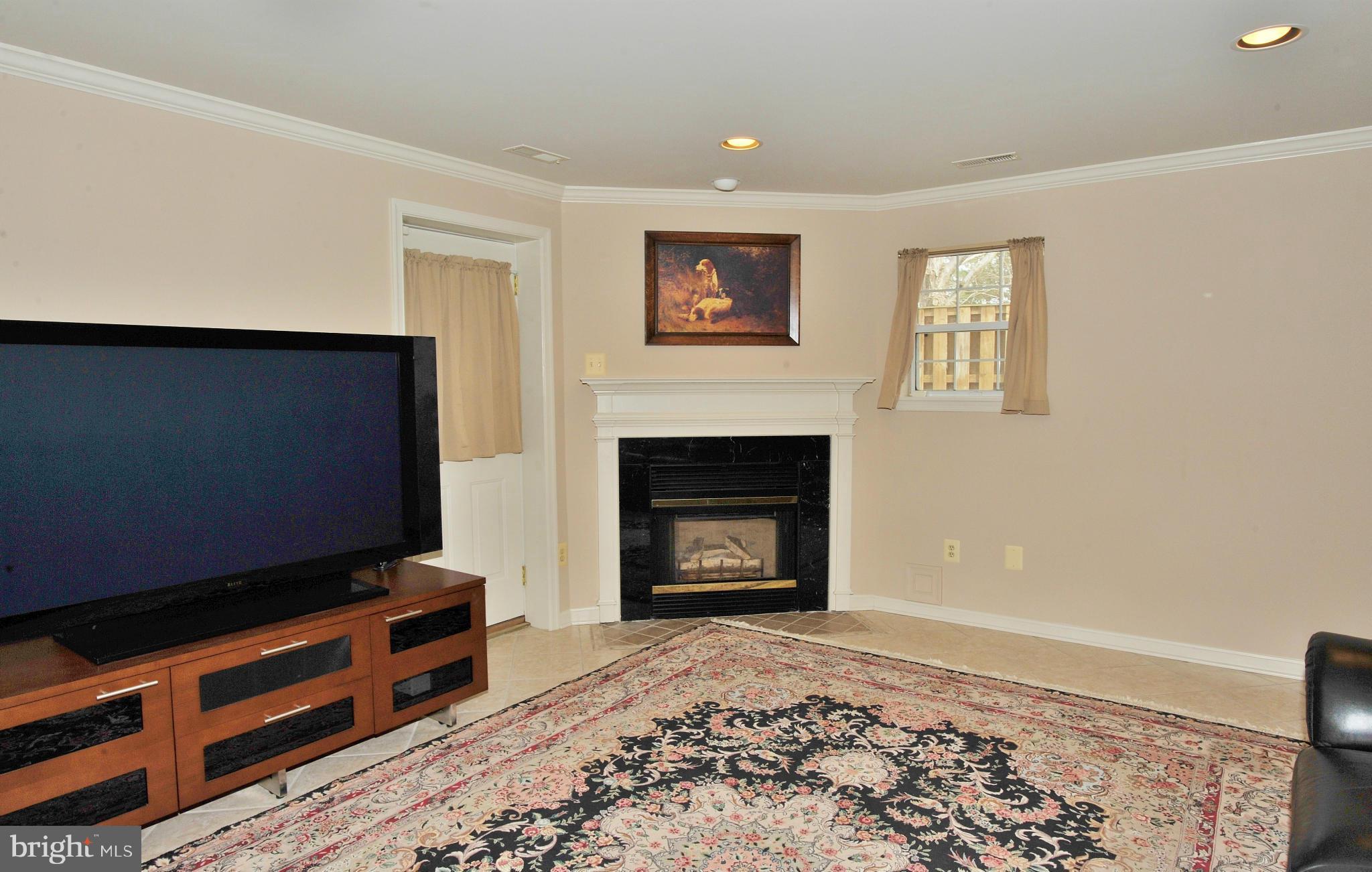 5700 Clapham Road Alexandria, VA 22315 - Photo 16 of 30 a living room with furniture a fireplace and a flat screen tv