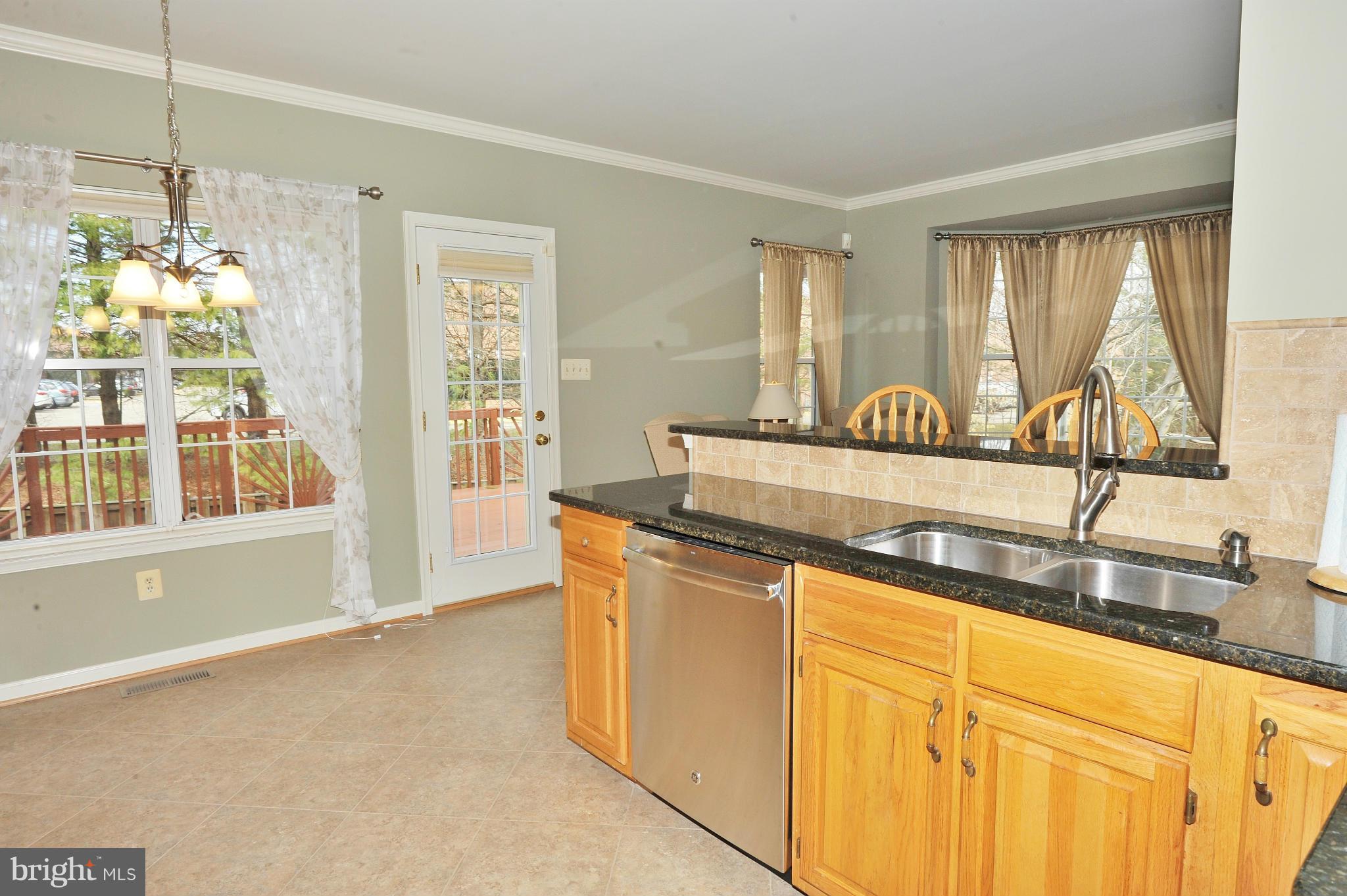 5700 Clapham Road Alexandria, VA 22315 - Photo 3 of 30 a kitchen with stainless steel appliances granite countertop a sink a stove and a granite counter tops with a large window