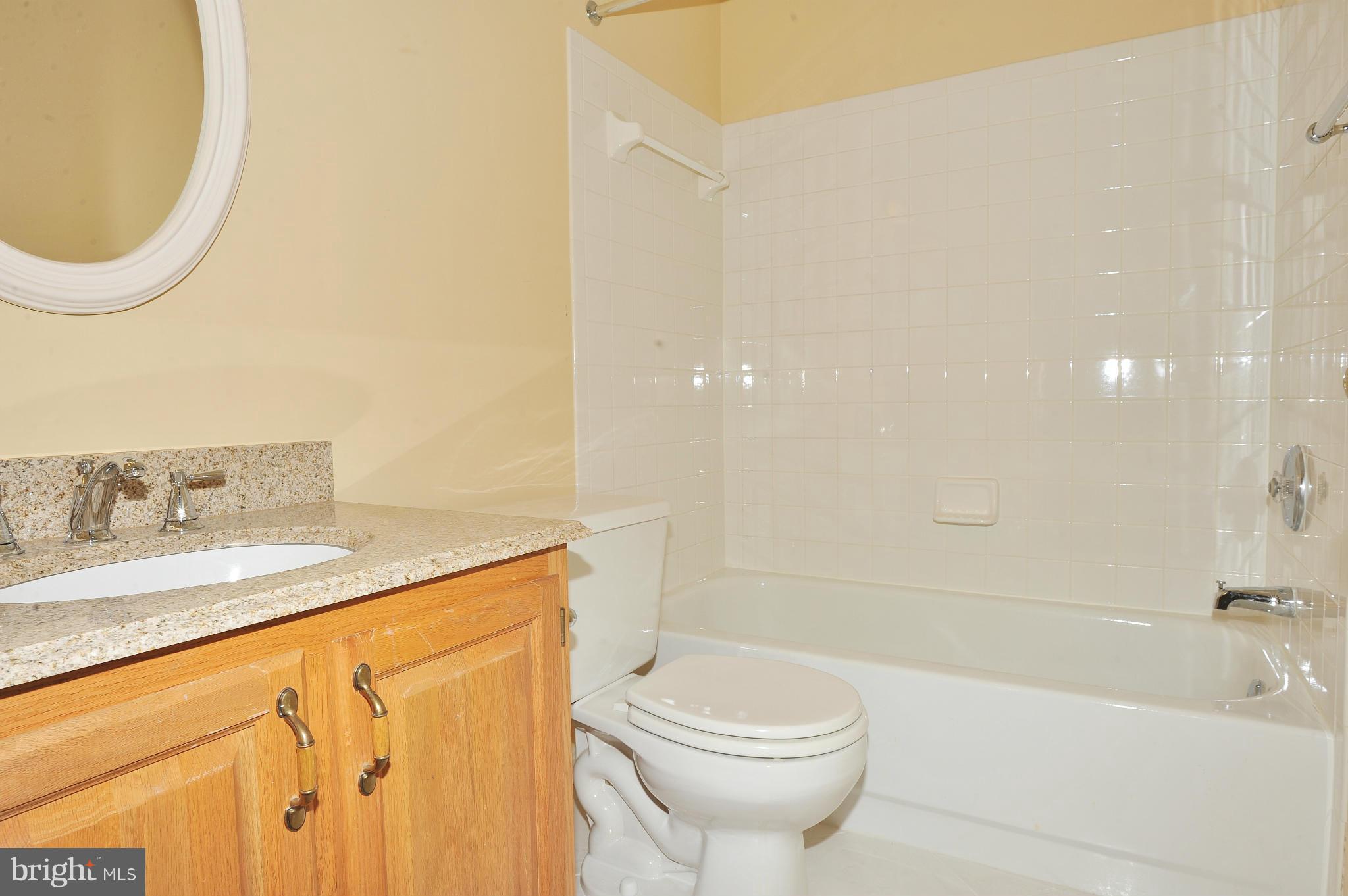 5700 Clapham Road Alexandria, VA 22315 - Photo 26 of 30 a bathroom with a granite countertop sink a toilet and bathtub
