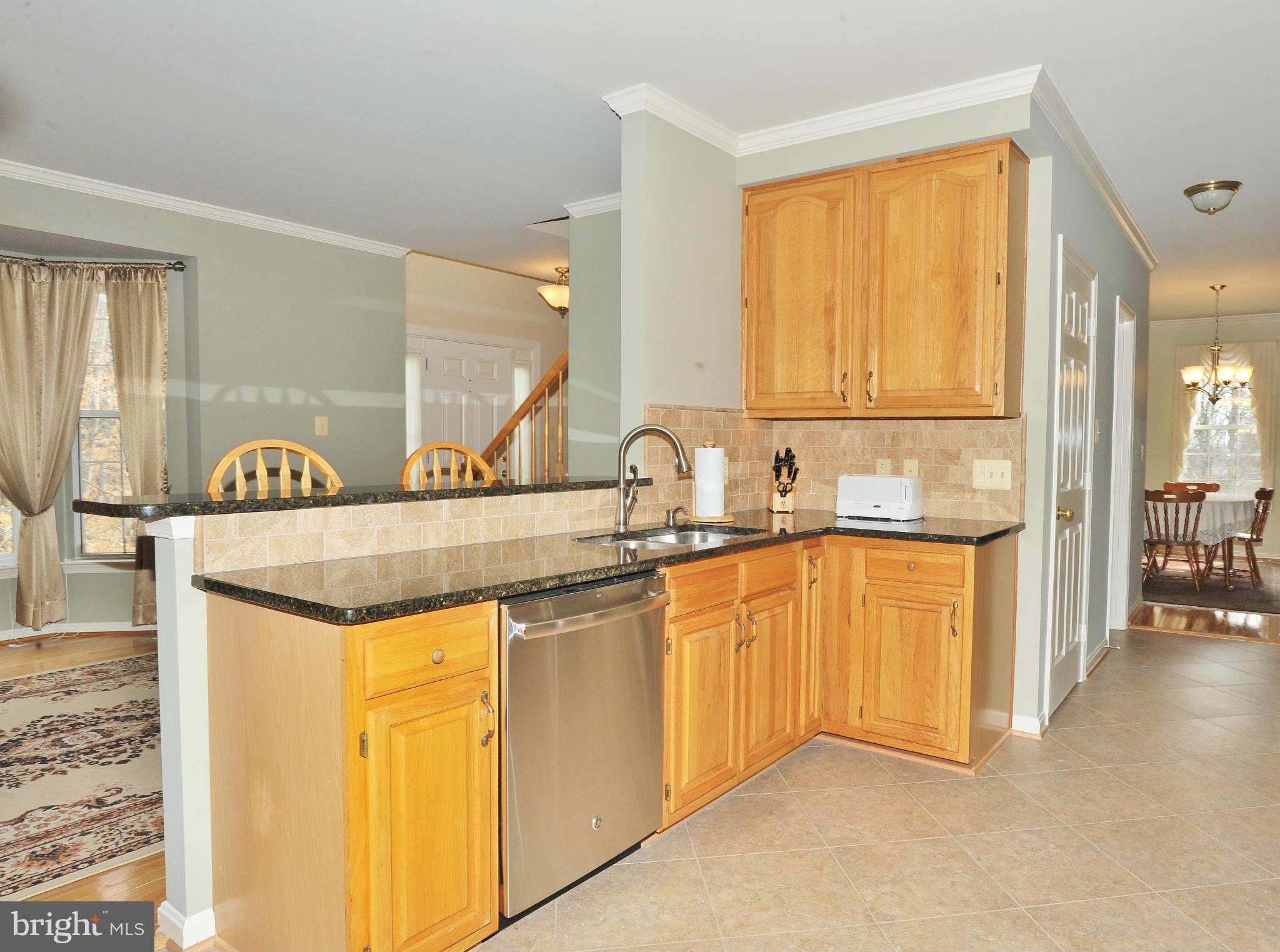 5700 Clapham Road Alexandria, VA 22315 - Photo 4 of 30 a kitchen with stainless steel appliances granite countertop a sink and a refrigerator