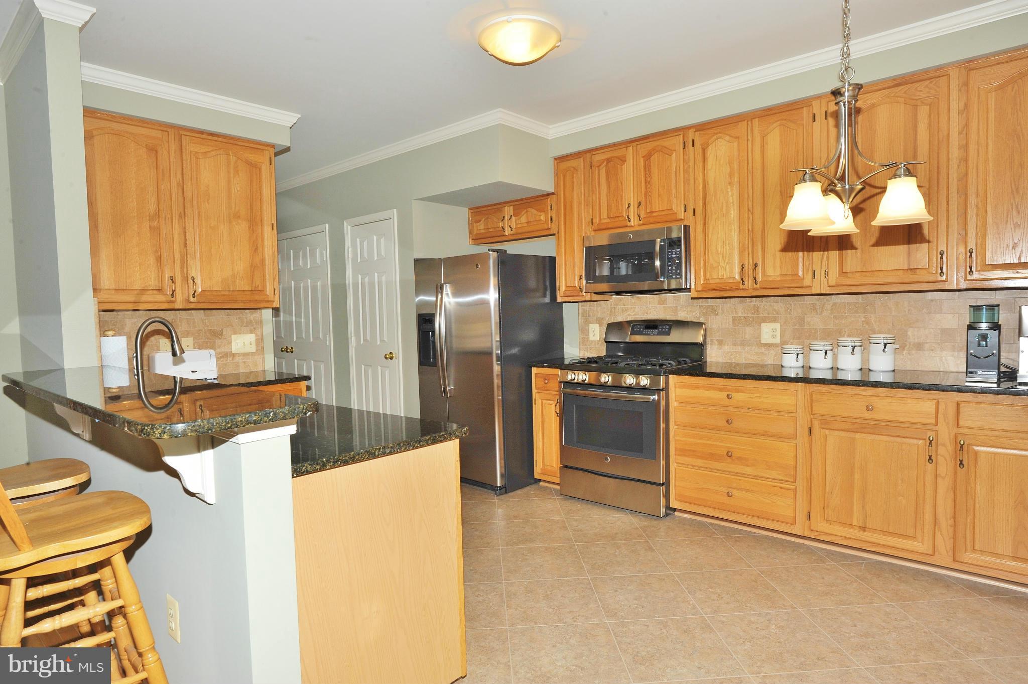 5700 Clapham Road Alexandria, VA 22315 - Photo 5 of 30 a kitchen with granite countertop a refrigerator stove top oven a sink and dishwasher