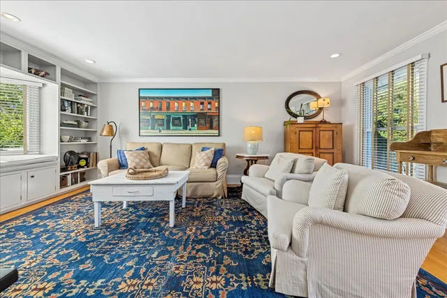 a living room with furniture a flat screen tv and a large window