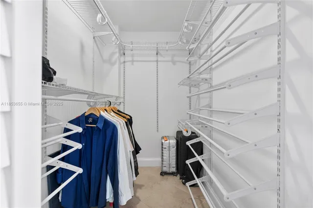 a view of walk in closet with clothes and shoes